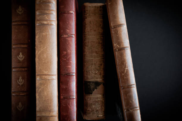 istock Row of old books on black background 1331811423