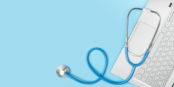 laptop keyboard and stethoscope on blue background. online medicine, telemedicine, doctor online consultation. online medical consultation. Telemedicine concept. copy space, top view, banner