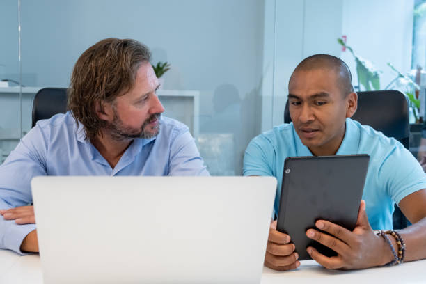 istock Colleagues talking and using a laptop and digital tablet in an office 1331814268