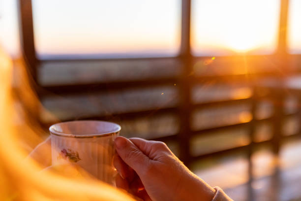 istock Woman holding tea cup and enjoying sunset 1331815545