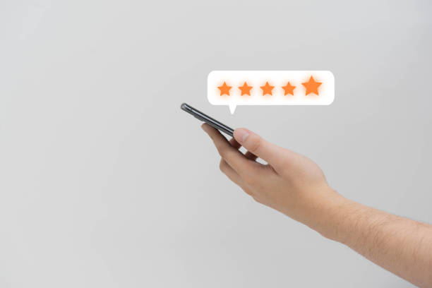 istock close up on customer man hand pressing on smartphone screen with  five star rating feedback icon and press level good rank for giving best score point to review the service , technology business concept 1331816477