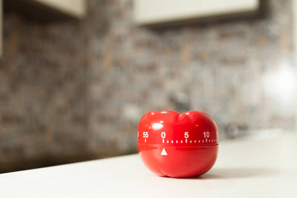 minuterie de cuisine rouge en forme de tomate avec cuisson en arrière-plan. - timer cooking domestic kitchen time photos et images de collection