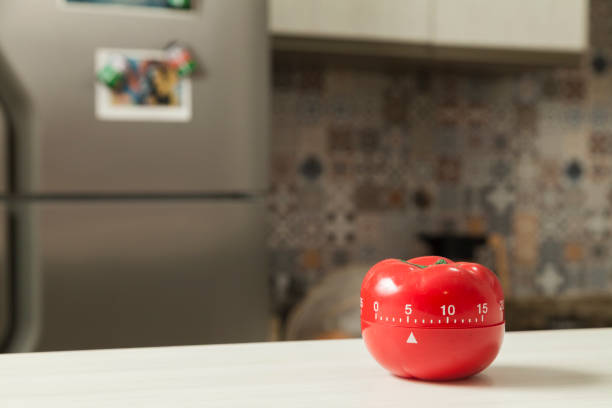 temporizador de cocina en forma de tomate rojo con cocina en el fondo. - salsa de tomate fotos fotografías e imágenes de stock