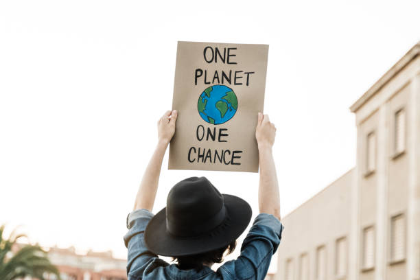 istock Demonstrator on the city protesting against climate change and pollution - Global warming and environment concept - Focus on banner 1331817626