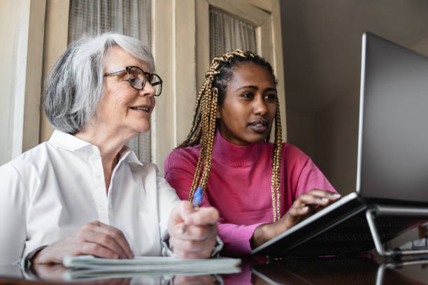istock Multiracial young and senior people using computer laptop indoor at home - Multi generational people working inside office - Focus on african girl face 1331817762