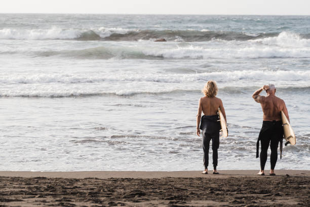 istock Father and son having fun on the beach at summer sunset for surf training - Focus on backs 1331818638