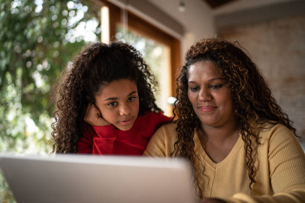 istock Mother and daughter using laptop at home 1331819776