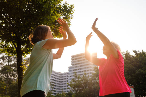 istock Grandmother and granddaughter clapping hands at sunset during training. 1331822109