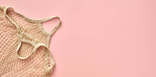 istock Ecological organic cotton mesh bag on pastel pink background with copy space 1331826260
