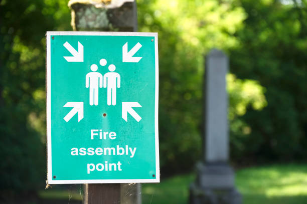 señal de punto de montaje de incendios en el poste indicador del lugar de trabajo - fire escape fotografías e imágenes de stock