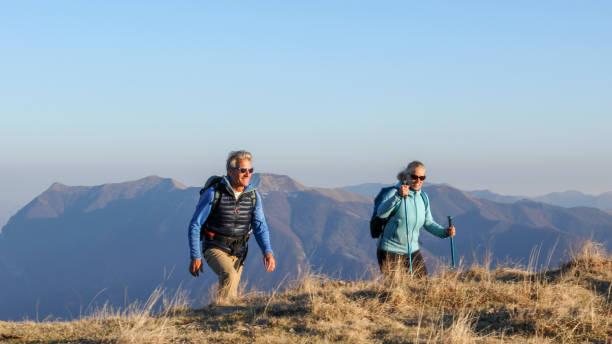 istock Mature couple hike along grassy mountain ridge 1331835732
