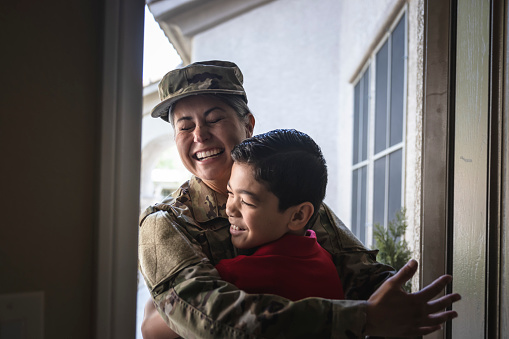 A mother in the Military returning home to greet her son at home.