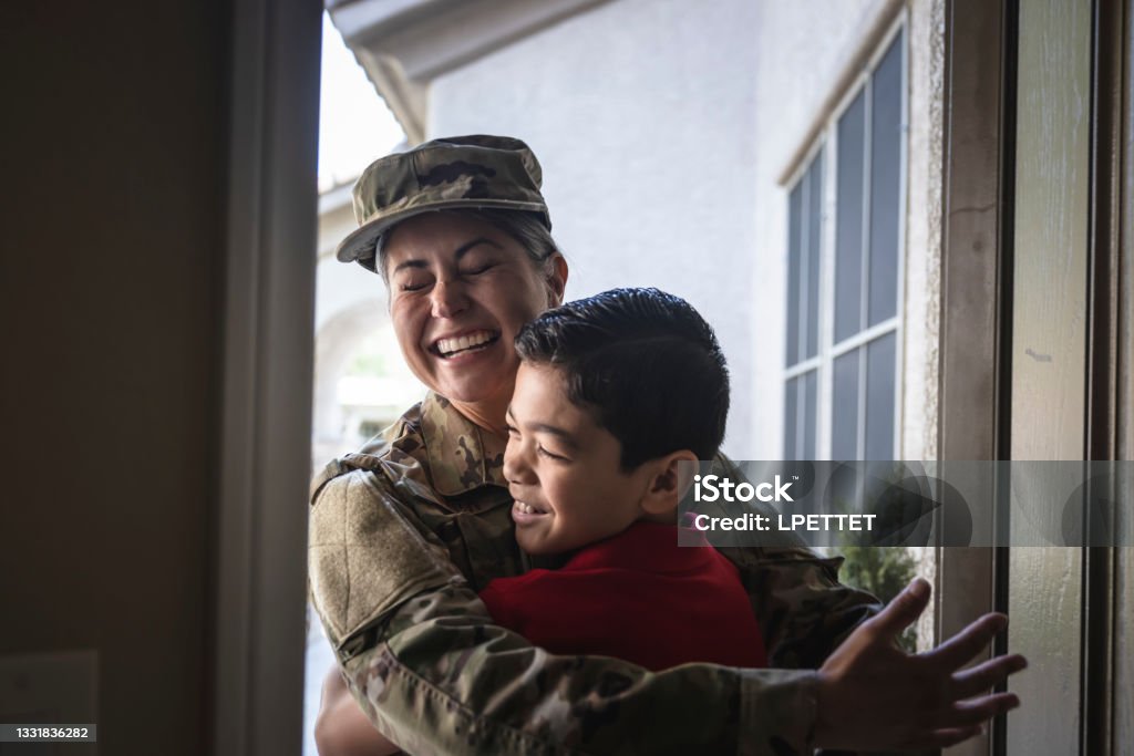 Military Mother Returning Home A mother in the Military returning home to greet her son at home. US Military Stock Photo