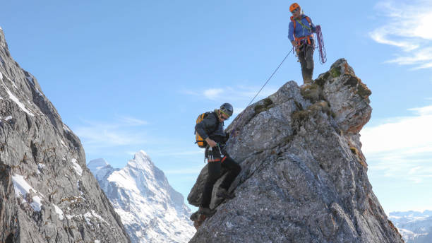 istock Mountaineers belay each other up mountain summit 1331838697