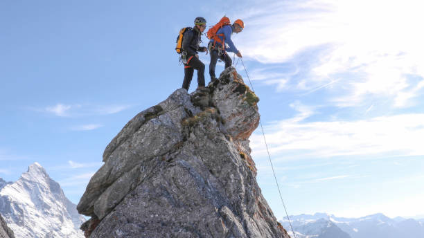 istock Mountaineers prepare to rappel off mountain summit 1331838794