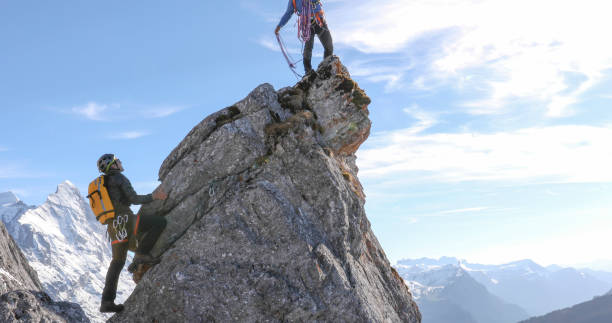 istock Mountaineers belay each other up mountain summit 1331838801