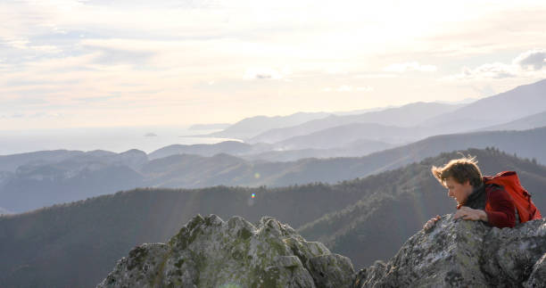 istock Mountaineer climbs up to mountain summit 1331838803