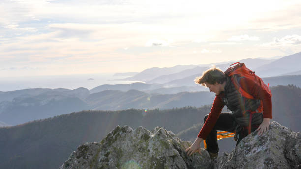 istock Mountaineer climbs up to mountain summit 1331838809