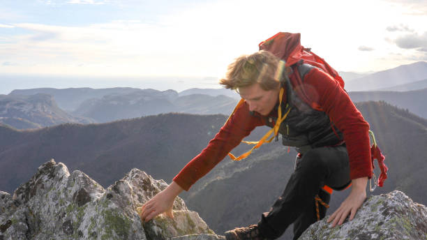 istock Mountaineer climbs up to mountain summit 1331838913