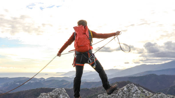 istock Mountaineer organises rope on mountain summit 1331839018