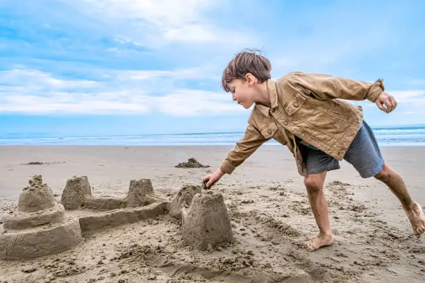 Caucasian Little boy playing with sand castles at the beach