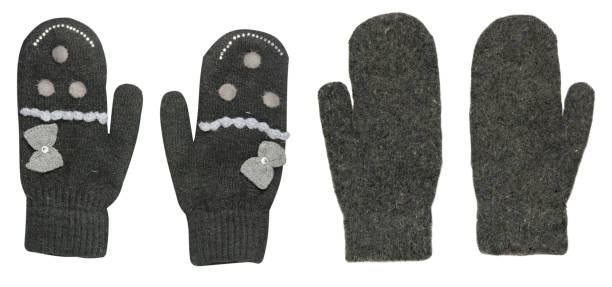 Female vintage style knitted mittens. Woman beautiful white mittens with a pattern of flowers on rustic wooden background, copy space. Winter fashion accessory.