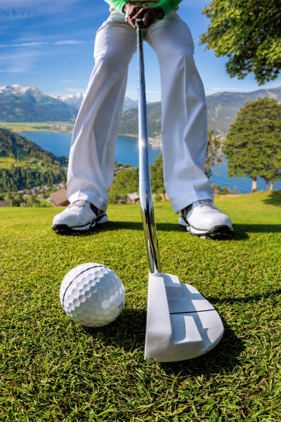 Man playing golf against famous Zell am see in Austria Man playing golf against famous Zell am see in Austria water athlete competitive sport vertical stock pictures, royalty-free photos & images