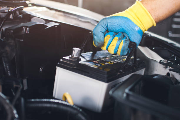 Technician replaced car old battery Technician is pulling up an car old battery for replacement replacement stock pictures, royalty-free photos & images