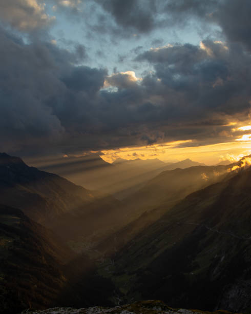 удивительный пейзаж в самом сердце швейцарии. эпические пейзажи с облаками и туманом. чудесные солнечные лучи сквозь облака, а позже удивит - switzerland european alps mountain alpenglow стоковые фото и изображения