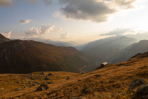 paesaggio incredibile nel focolare del canton bernese in svizzera. guida sul grimselpass. paesaggi epici con nuvole e nebbia. meravigliosi raggi del sole tra le nuvole e in seguito un tramonto e un'alba incredibili. viaggio perfetto attraverso la svizzera. - switzerland european alps mountain alpenglow foto e immagini stock