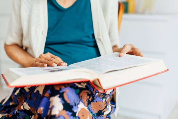 istock Old Woman Reading Book 1331849381