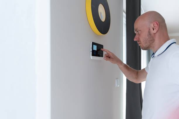 istock A man presses buttons on the control panel to disarm the burglar alarm system. 1331850320