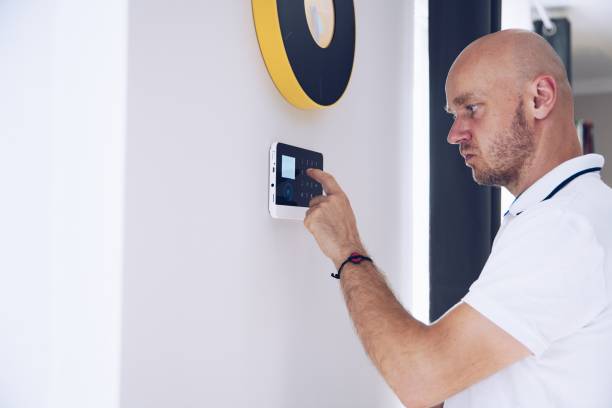 istock Man arming a home alarm on the wall. 1331850402