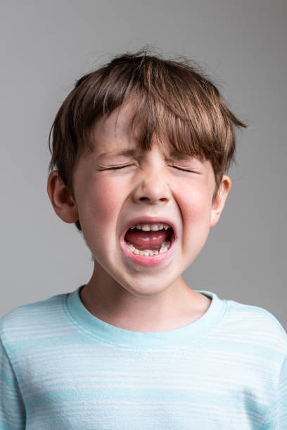 istock Crying caucasian little boy On gray background 1331852181