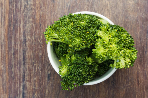 istock Broccoli in a small white pot isolated on a wooden cutting board. Selective focus. Top view 1331852984
