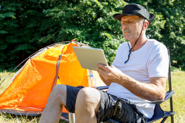 istock Serious mature camper observing digital tablet 1331855945