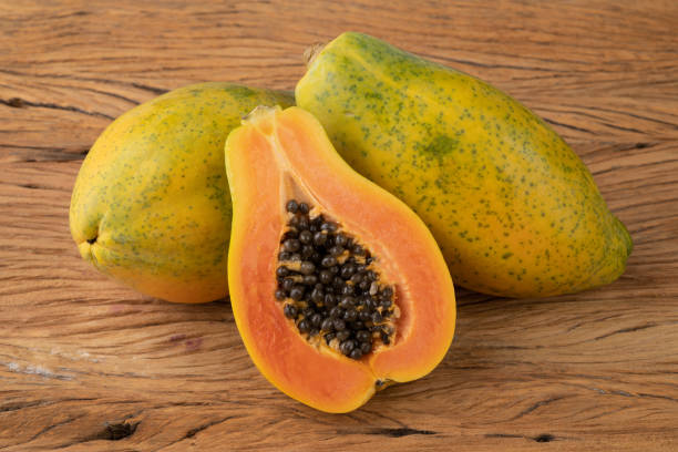 istock Papayas with half fruit over wooden table 1331863826