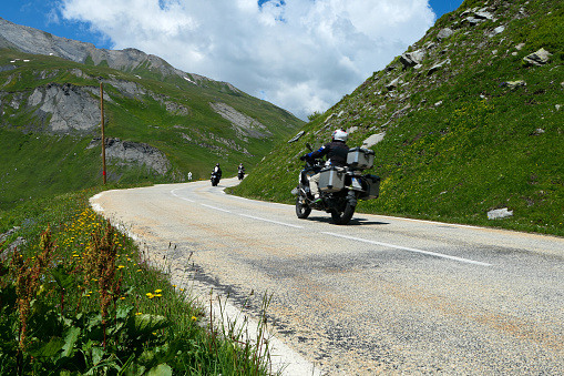 La rosière, France. July 18. 2021. Winding mountain road with a motorcycle that passes in a bend.