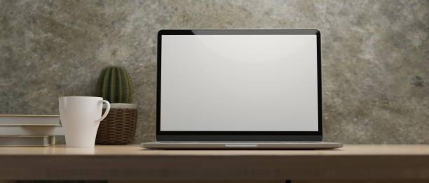istock Laptop display for mockup on wood table at home office, cement wall 1331872054