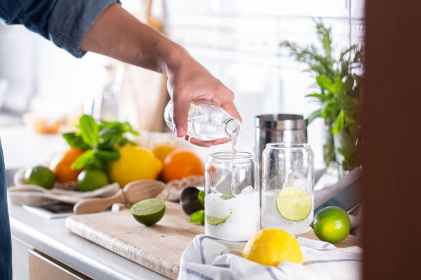 mixólogo haciendo cóctel refrescante con hard seltzer en casa - instructor one person fruit drinking fotografías e imágenes de stock