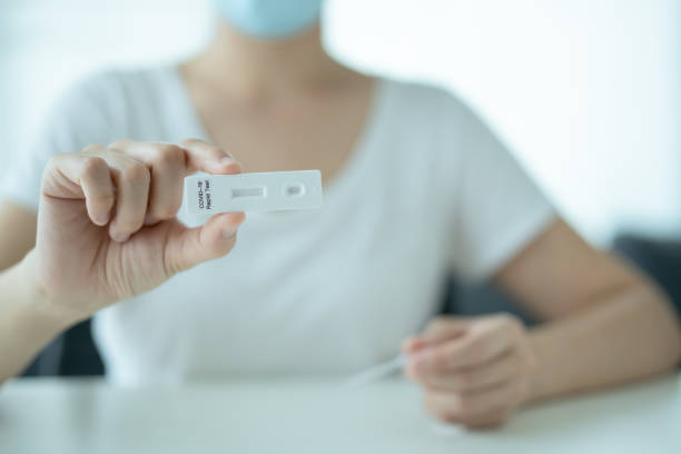 istock Woman using COVID-19 ag test kit. 1331878408