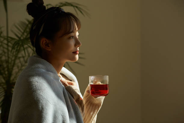 istock A young Asian woman relaxing at home drinking fruit tea 1331879432