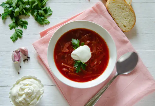 The national Russian and Ukrainian dish is red borscht with beetroot and cabbage. Served in white dishes on a light background