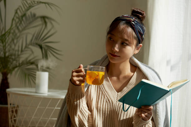 istock A young Asian woman relaxing at home drinking fruit tea 1331881444