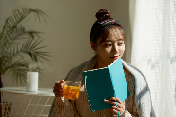 istock A young Asian woman relaxing at home drinking fruit tea 1331881514