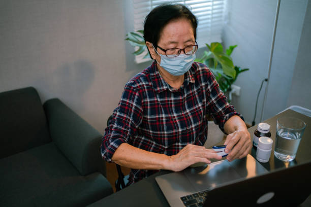 istock Senior Woman Using Pulse Oximeter and laptop, Measuring Oxygen Saturation 1331884388