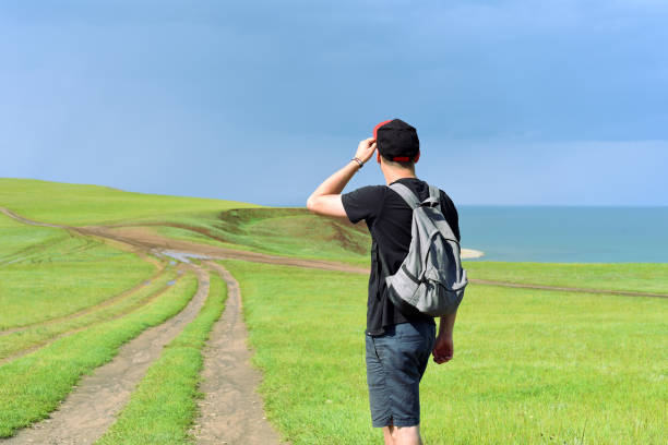 Young man with backpack choosing a path to the Cape Kharantsy