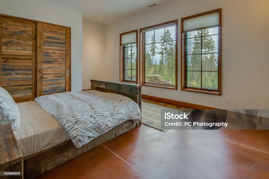 Open and bright bedroom in new home Beautiful views and wood floors Bedroom Stock Photo
