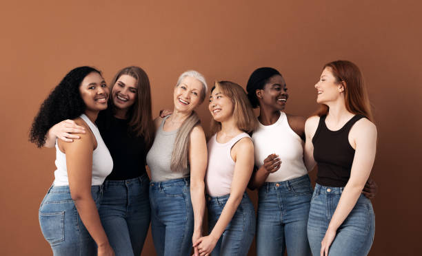 Cheerful women of different body types and ages standing together in studio Cheerful women of different body types and ages standing together in studio age contrast stock pictures, royalty-free photos & images