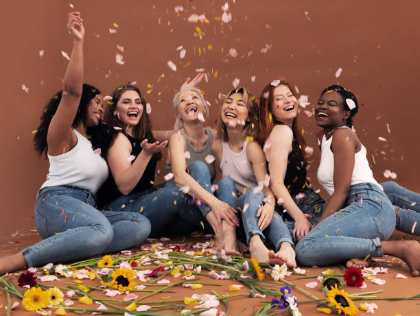 istock Multi ethnic group of happy women sitting under falling petals 1331892506